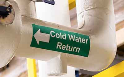 A label on a pipe that says "Cold Water Return."