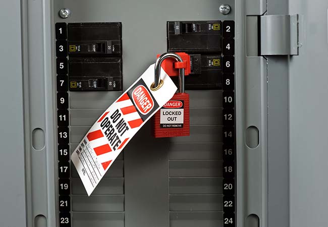 Lockout padlock attached to an electrical panel showcasing proper lototo procedures.
