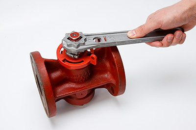 An individual performing a lockout tagout inspection, carefully securing a lockout device to verify its proper functionality.