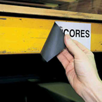 A person peeling a magnetic label from a surface with ease.