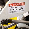 A Danger pinch point label with warning graphic applied to a pice of equipment.