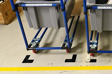 An area for carts is neatly marked using floor tape.