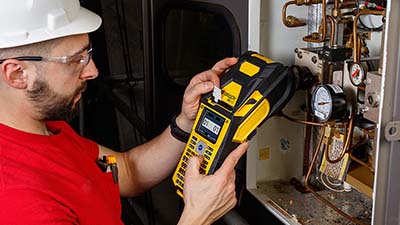 An electrician marking wires on a machine.