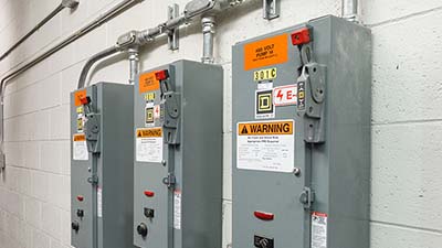 Industrial breaker boxes with arc flash warning labels.