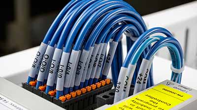 Dozens of neatly labeled wires connect to a terminal block.