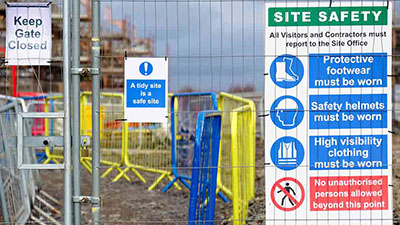 A fence with a large site safety sign.