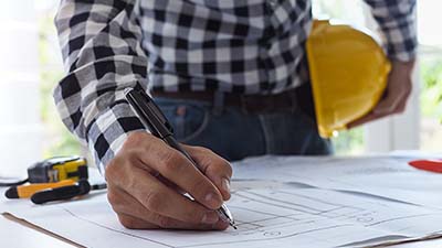 An engineer works on a technical drawing.