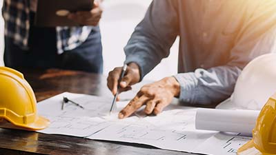 A person points to an area in a blueprint.