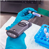 A lab technician scans the barcode label on a blood vial.