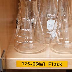 A shelf with flasks is labeled.