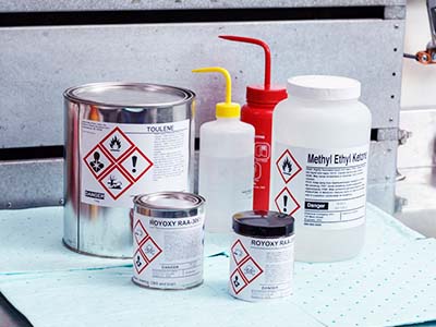 A variety of containers marked with hazardous material labels.