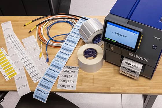 A worker applies an asset tag to a laptop.