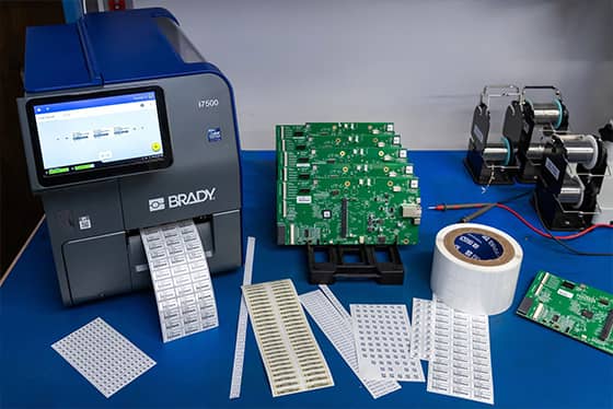 A worker applies an asset tag to a laptop.