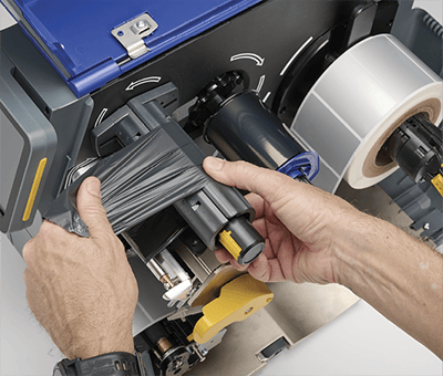An employee quickly loading an i7500 printer with a new ribbon.