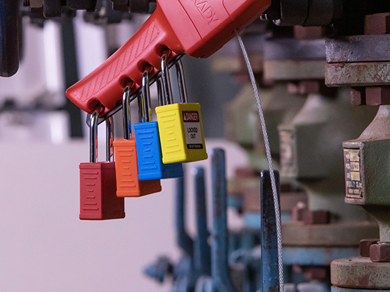 Four nylon padlocks hanging on a piece of industrial equipment