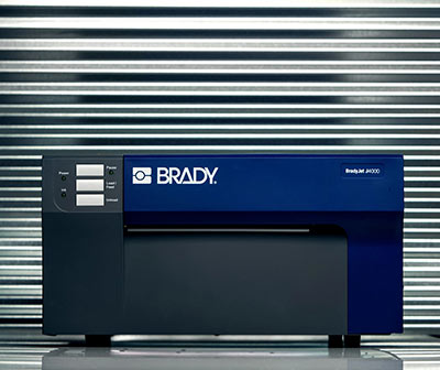 BradyJet J4000 industrial label printer sitting on top of a metal shelf