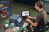 A man using a Brady S3100 printer to print signage and identify construction safety hazards.