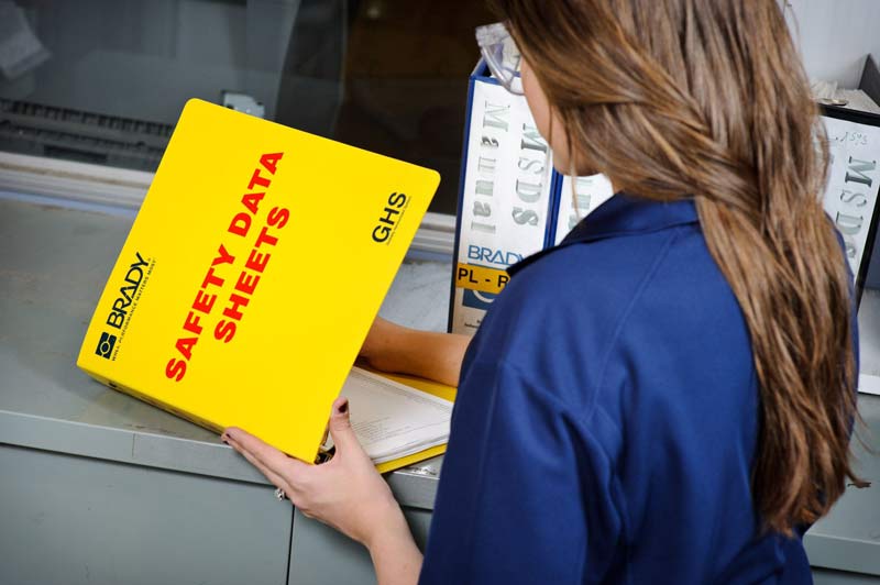 A worker looking through a Safety Data Sheets binder