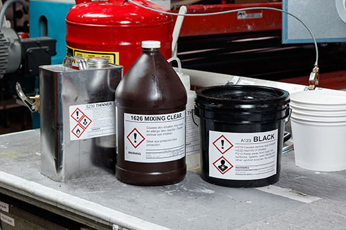 Different containers with GHS labels sitting on a work bench