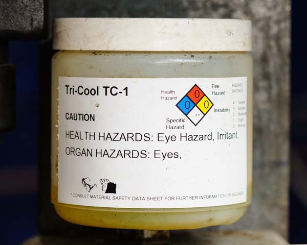 A bottle of Tri-Cool TC-1 chemical solution labeled with a 'Right to Know' label, providing essential safety and hazard information.