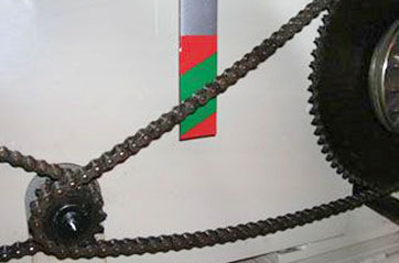 A chain is being used to turn gears inside a machine.
