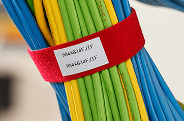 A labeled BradyGrip hook bundling several dozen cords together and keeping them organized.