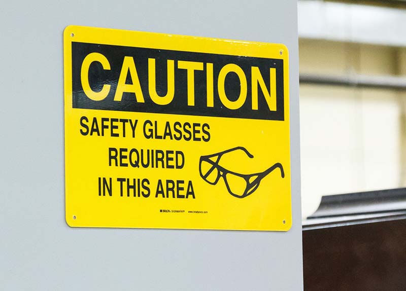 Safety sign telling workers that safety glasses are required in the industrial environment.