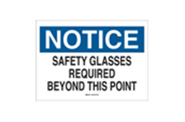 A sign that says "NOTICE SAFETY GLASSES REQUIRED BEYOND THIS POINT."