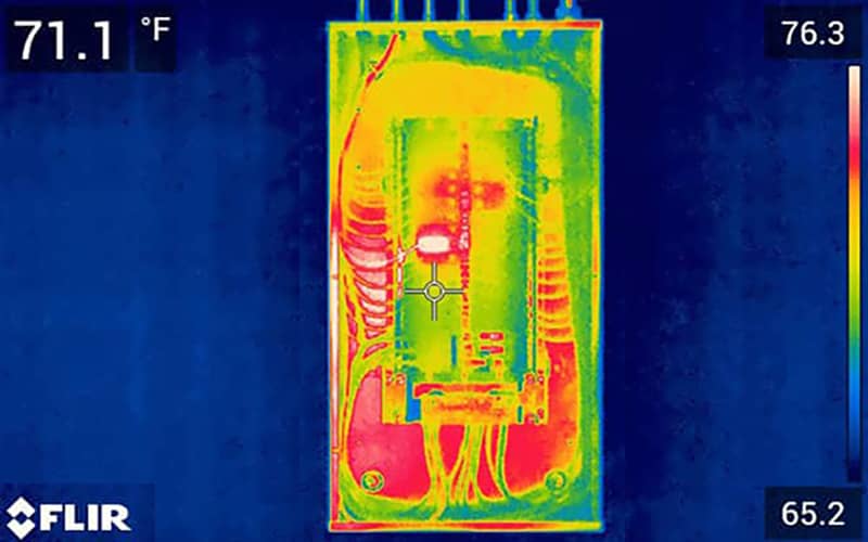 An electrical panel viewed through a thermal camera showing different temperatures by color.