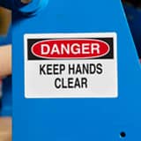 A danger label with the legend "Keep Hands Clear" applied to an industrial machine.
