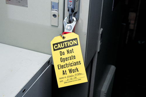 Accident prevention tag example: says 'Caution, do not operate. Electricians at work'