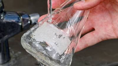 A glass flask with a Brady dissolvable label being cleaned and having the label removed.
