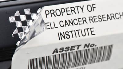 A asset label applied to a piece of equipment that is peeled back revealing a metallic checkerboard pattern to identify the label has been removed.