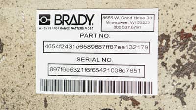 A Brady high adhesion rating plate label appliec to a worn piece of industrial equipment.