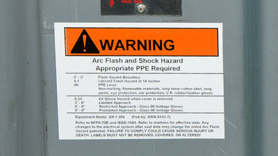 An arc flash hazard warning label on an electrical panel with information on safety requirements.
