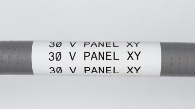 A white label on a conduit, reading 