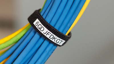 Bradygrip hook on labels wrapped around, securing and identifying a group of data cables.