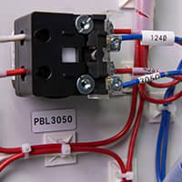 A Brady label identifying a wire on a control panel